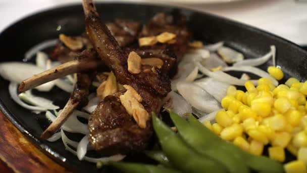 熱い鍋 でラムのステーキのラックを食べる手の保有物 — ストック動画
