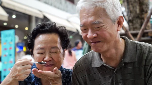 Liebevolle asiatische ältere Paar Fütterung Eis glücklich Dating im Freien — Stockfoto