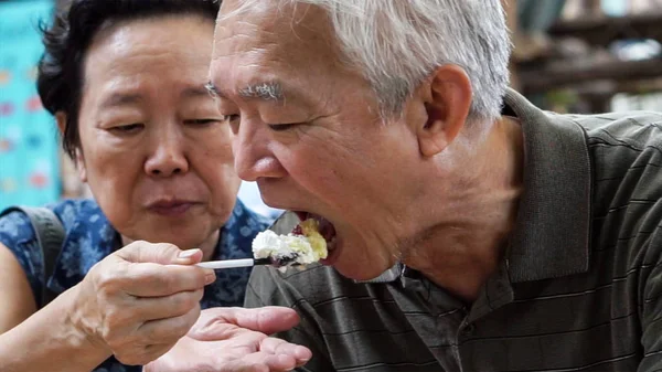 Liebevolle asiatische ältere Paar Fütterung Eis glücklich Dating im Freien — Stockfoto