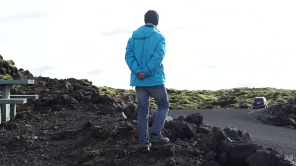 アジア人の男性は 苔むした火山の風景でアイスランドで楽しんでいます — ストック動画