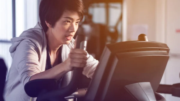 Specchio riflettono asiatico donna esercizio palestra bicicletta concentrazione — Foto Stock