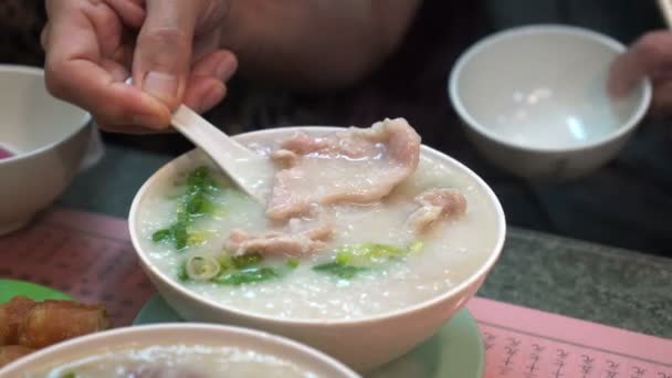 Hands Eating Hong Kong Cantonese Congee Bolws Tough Sticks — стоковое видео