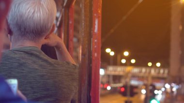 Hong Kong tramvayında oturan Asya 'lı yaşlı adam.