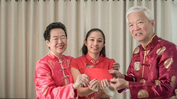 Familie groet rode envelop bij Chinees Nieuwjaar viering — Stockfoto