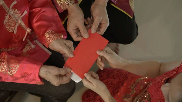 中国の旧正月のための赤い封筒を与えるトップビュー祖父母と — ストック写真