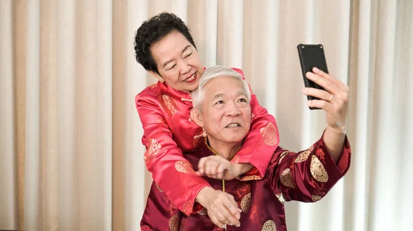 Coupld sênior chinês usando telefone para crianças no chinês New Yea — Fotografia de Stock