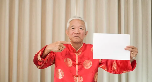 Asijské Senior muž držení znamení s kopií prostoru pro čínský nový rok překvapení dohoda — Stock fotografie