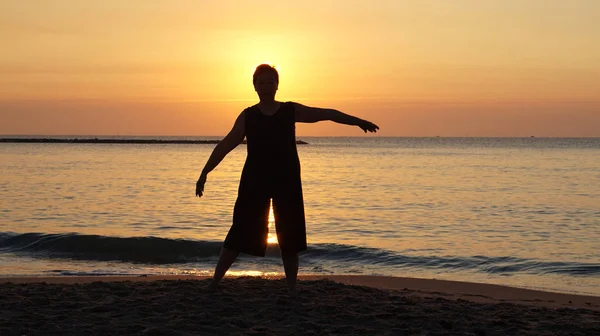 Asian elder woman silhouette at beach happy found purpose of life