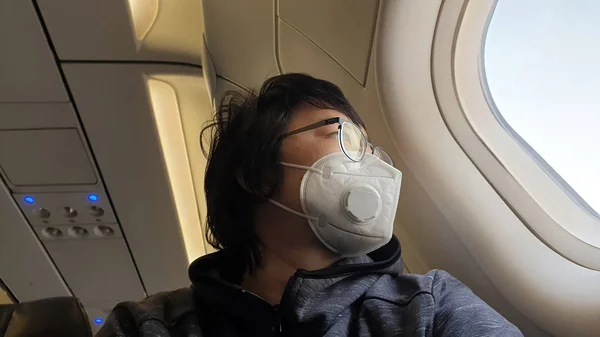 A repülőgépen való felszállás közben maszkot viselő kínai utazó 2019-től megakadályozza a Novel Coronavirus terjedését. — Stock Fotó