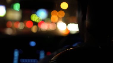 Gece trafik ışığı deri koltuğun arkasındaki arabanın arka plan görüntüsünü bulanıklaştırır