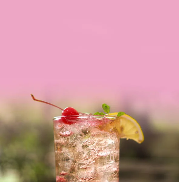 緑の自然を背景にレモンと夏の氷冷たい赤チェリーソーダ — ストック写真