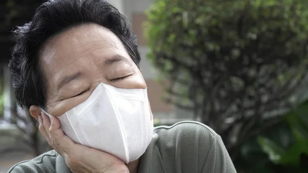 Asian Chinese elder wearing N95 mask protection from smog and Coronavirus