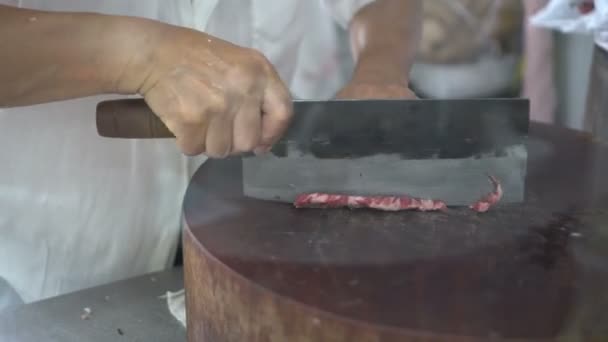 香港中国人シェフは鍋に脂肪分の多い牛肉をスライスするためにクリーバーを使用 — ストック動画