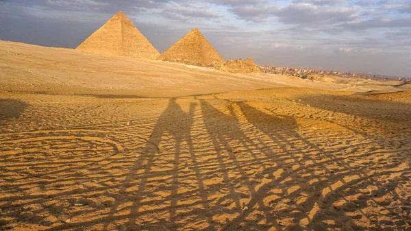 Piramidi Giza Tramonto Ombra Cammelli Camminare Città Vista Sfondo — Foto Stock