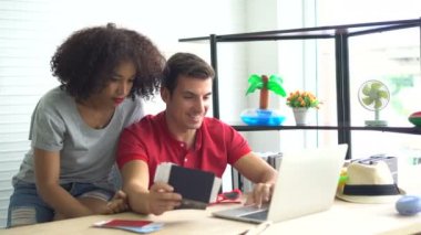 Irklar arası Afrikalı ve İspanyol çiftler evden internet üzerinden tatil bileti alıyorlar.