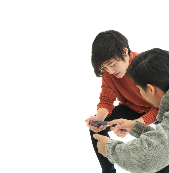 Two Asian friend sharing application and information on mobile phone