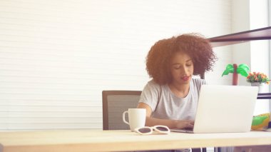 Ev defterinden ve kahveden çalışan Afrikalı bir kadın.