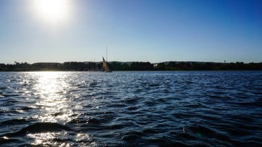 Mısır 'da Nil Nehri' nde, parlak güneşli mavi gökyüzüyle fellucca yatıyla.