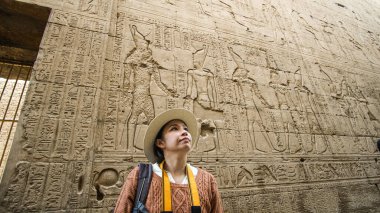 Asyalı turist kadın Edfu Tapınağı ile fotoğraf çekiyor Mısır 'ın iç kısımları Horus tanrısı