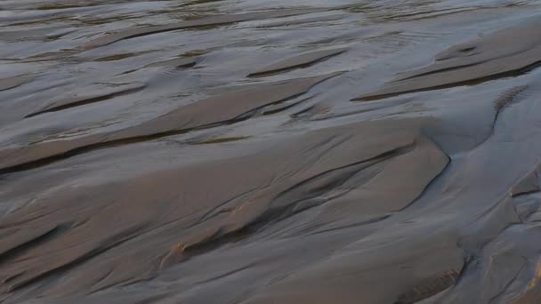 Schnelles Strömen von Schmelzwasser entlang des Sandes. — Stockvideo