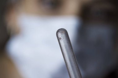 Tıbbi kavramı: doktora mavi kauçuk eldiven bir kene ile tüp bebek tutan