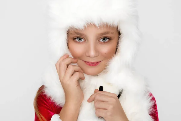 Stunning beautiful little girl with long blond hair , He has on his head a white cap with fur, — Stock Photo, Image