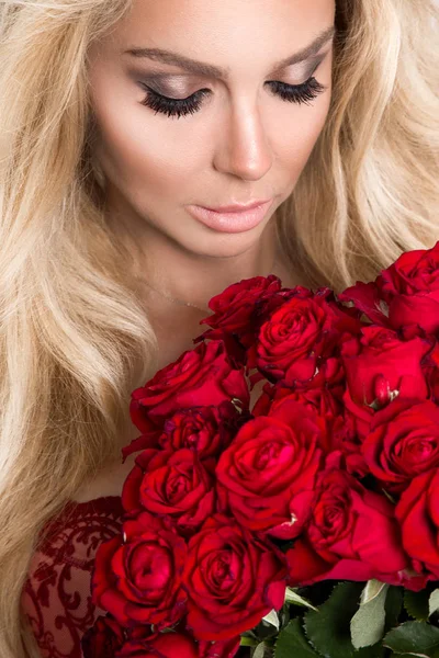 Beautiful sexy blonde woman and amazing looks and long hair, perfect skin, she hold bouquet of red roses flowers Valentine's Day — Stock Photo, Image