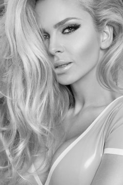 Pembe bir arka plan ve sevinçle gülümsüyor üzerinde pembe elbise duran uzun sarı saçlı güzel kadın modeli giymiş