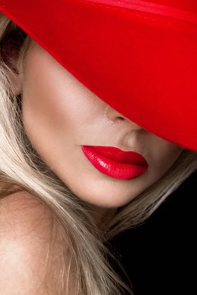 검은 바탕에 빨간색과 매혹적인 입술 빨간 모자에 아름 다운 금발 여자 — 스톡 사진
