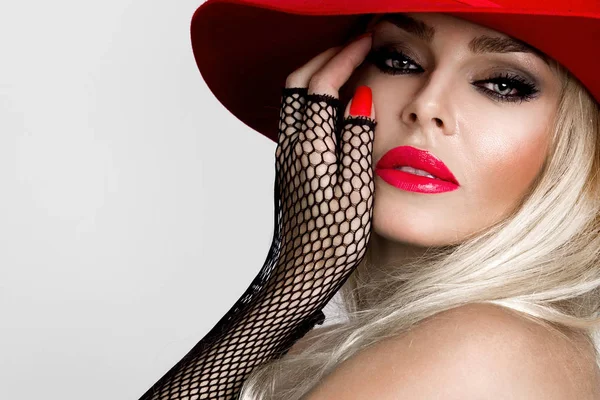 Güzel çıplak erotik eldiven, kırmızı şapka ve kırmızı dudakları bir şirin makyaj ve duyusal ağız siyah bir zemin üzerine çarpıcı, sarışın modelinde
