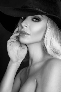 Güzel sarışın kadın, kırmızı dudaklar, seksi model siyah iç çamaşırı kıyafeti vücut mayo ve siyah şapka ve uzun çizmeler diz giymiş