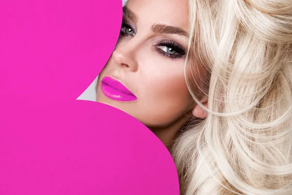 Güzel bir kadınla uzun sarı saç ayakta beyaz bir arka plan üzerinde kırmızı iç çamaşırı giymiş ve elinde kırmızı bir kalp Sevgililer günü tutar