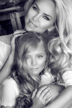 Bahar kıyafetleri ve çelenk doğada çiçeklerin güzel genç anne kızıyla birlikte giymiş