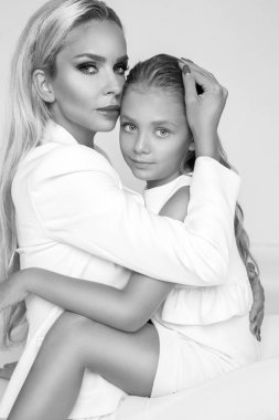 Güzel sarışın kadın model, sarışın kızı annesiyle sarıl. Onlar güzel tabaklanmış vücut var.