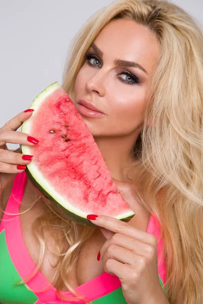 Güzel sarışın genç model, karpuz tutarak ve sevimli seyir tatlı kız.