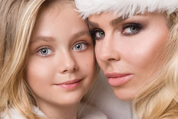 Piękny sexy blond matka z córka dziecko dziewczynka ubrana jak Santa Claus uścisk na Boże Narodzenie w zimy i śniegu — Zdjęcie stockowe