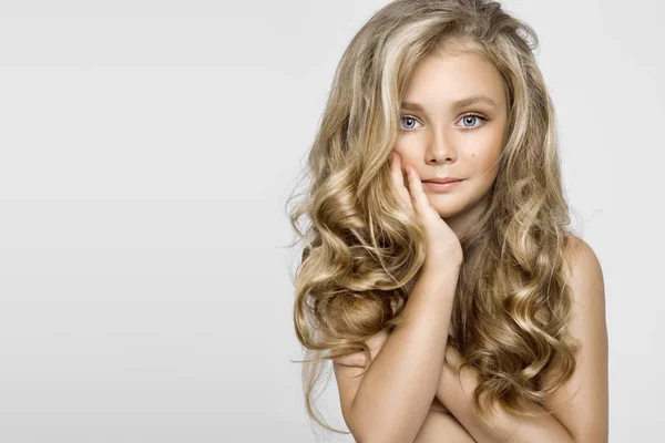 Vacker ung blond modell, Söt flicka med långa vackra hår på en vit bakgrund. Elegant liten flicka — Stockfoto