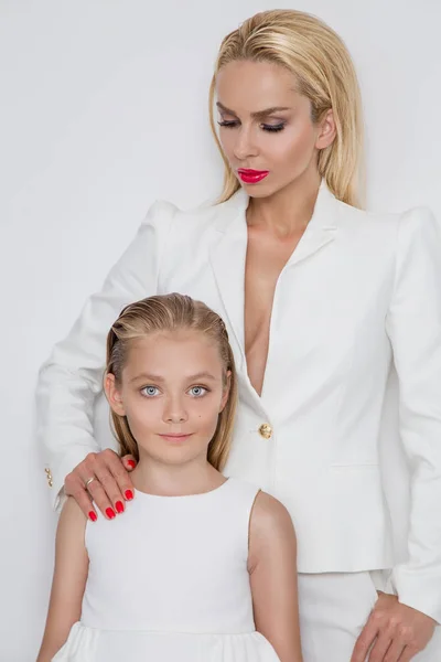 白い背景の上に立っているかわいい金髪娘と若い母親の美しさを見事な春服に身を包んだ — ストック写真