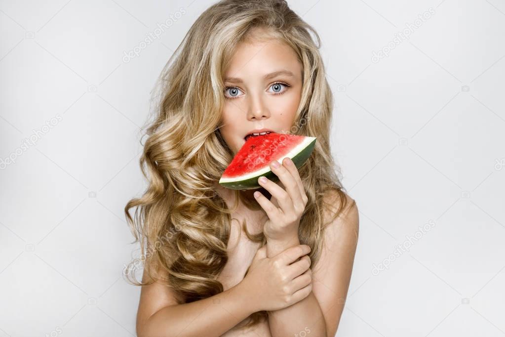 Beautiful blonde young model, cute girl, holding watermelon and looking cute.