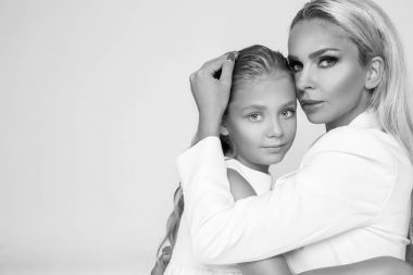 Güzel sarışın kadın model, sarışın kızı annesiyle sarıl. Onlar güzel tabaklanmış vücut var.