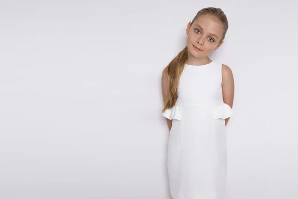 Портрет милої дівчинки-дочки в довгому світлому волоссі і білій сукні дивиться на камеру, фото на білому тлі дивовижні очі — стокове фото