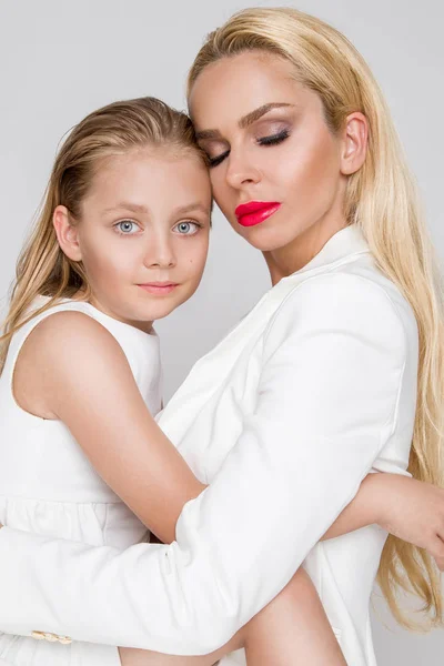 Vacker blond kvinnlig modell, mor med blond dotter kram. De har vackra solbrända kropp. — Stockfoto