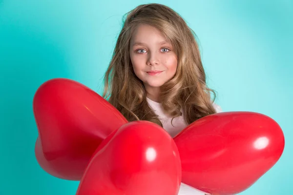 Bella splendida bambina bionda in jeans denim seduta su una sedia su uno sfondo blu — Foto Stock