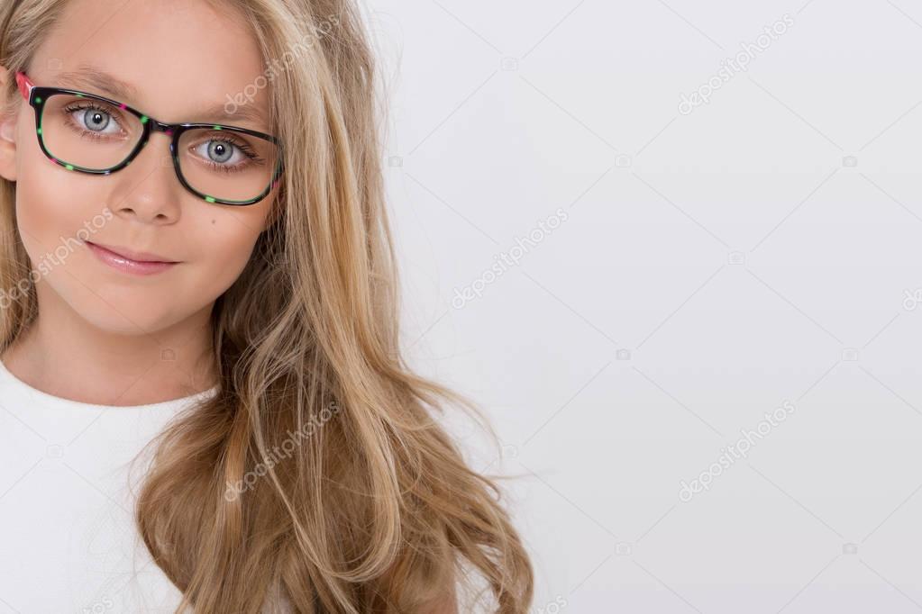 Cute little girl in a white communion dress, standing on a pink background