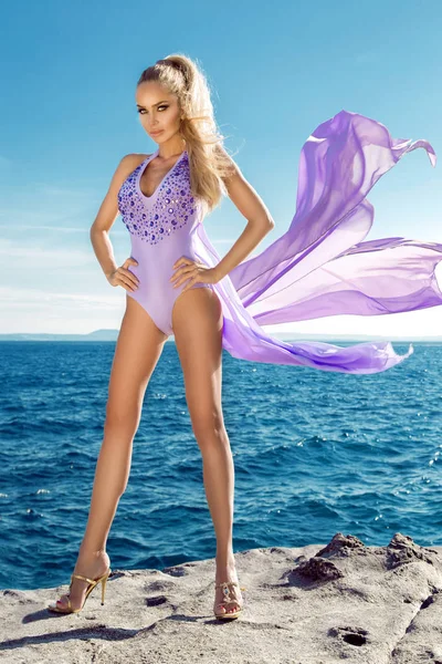 Modelo feminino loira deslumbrante e sexy com corpo perfeito vestindo um biquíni, maiô elegante na vista incrível com palmeiras mar em Cannes, Santorini — Fotografia de Stock