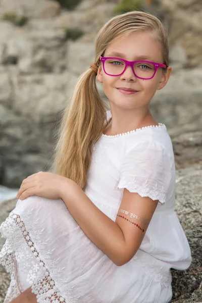 Retrato de una linda niña en gafas sobre un fondo blanco — Foto de Stock