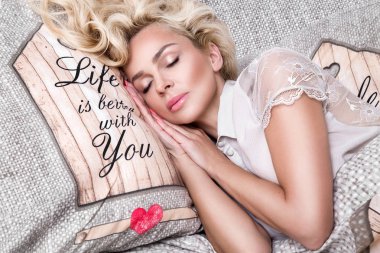 Güzel bir yüz ve şaşırtıcı gözleri, yalan, sarışın kadın portre güzel uyuyor üzerinde yatak çarşafları bir şık ve seksi görünüyor ve çapkın gülümseme