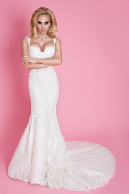 Güzel sarışın gelin gül ile dekore edilmiş bir salıncak üzerinde bir gelinlik