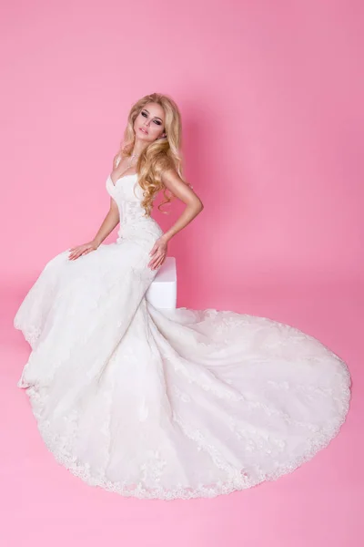 Красивая блондинка невеста в свадебном платье на качелях, украшенных розами — стоковое фото