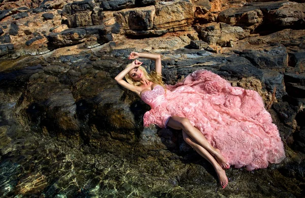 Hermosa modelo rubia femenina con un cuerpo perfecto y cabello largo increíble en la isla de Santorini en Grecia y alrededor de ella es increíble vista — Foto de Stock